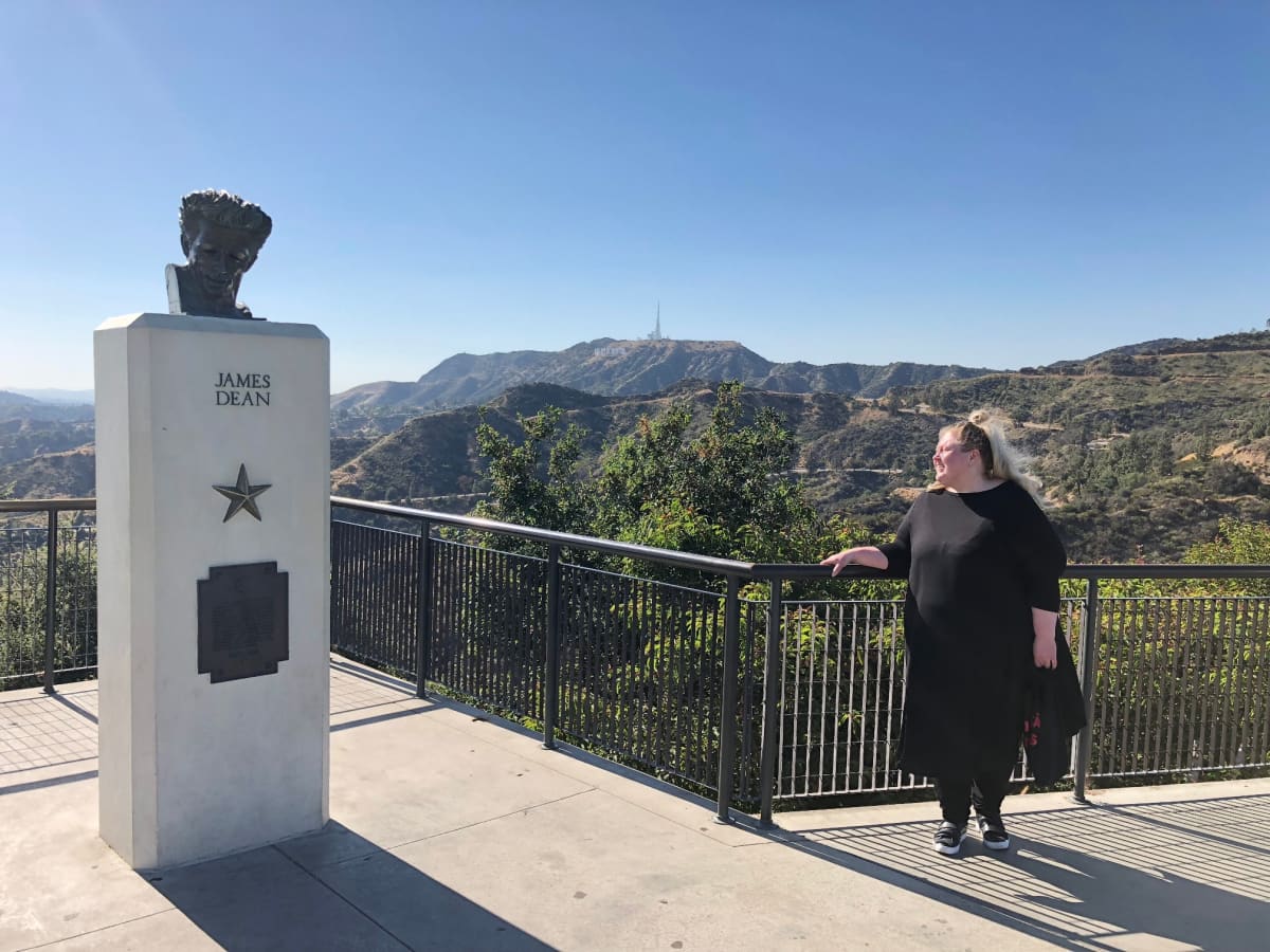 Valokuvataiteilija Iiu Susiraja Los Angelesissa James Deanin patsaan luona.