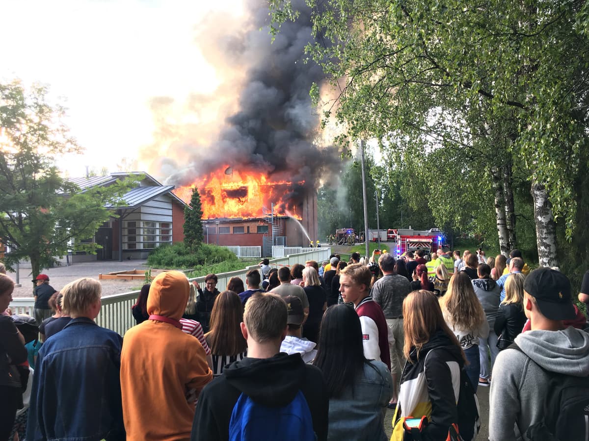 Tuppuralan koulu palaa Mikkelissä. Paloa on seuraamassa runsaasti yleisöä. Monet kuvaavat sammutustöitä.