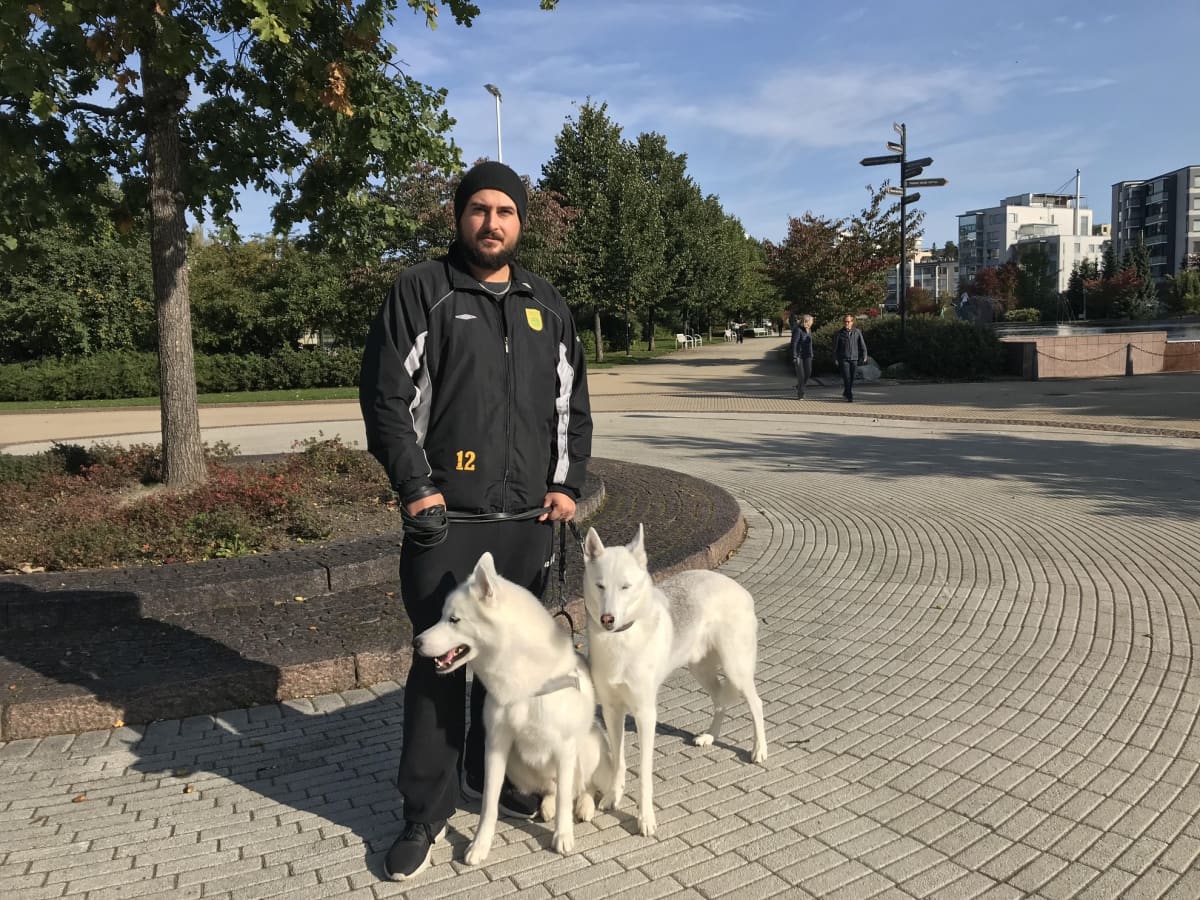 Abe Al-Sadani on ulkoiluttamassa kahta koiraansa.