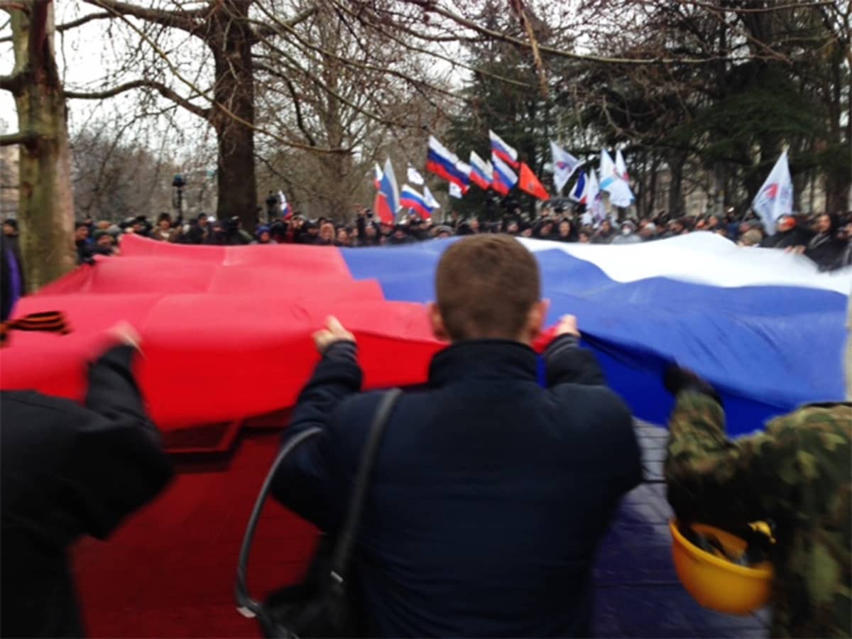 Mielenosoittajat kantavat lippua Simferopolissa.