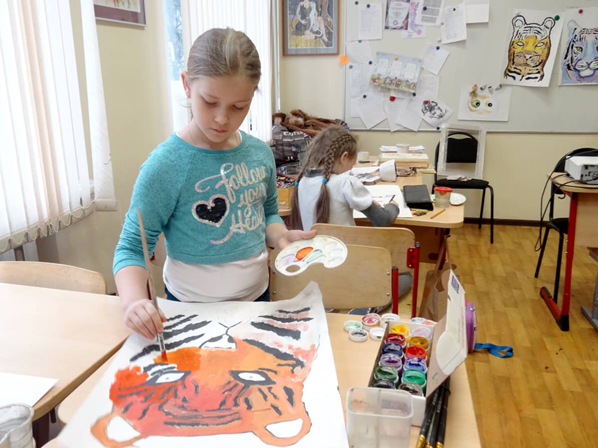 tyttö maalaa tiikeriä luokassa