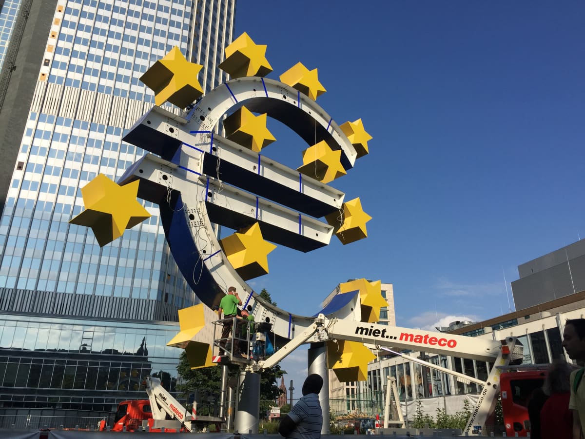 Eurorahan symbolia korjataan Euroopan keskuspankin edessä.