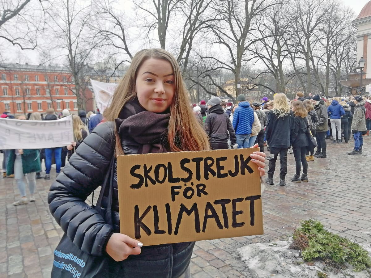 Mielenosoittajalla Turussa on kyltti, jossa lukee "Skolstreijk för klimaten."