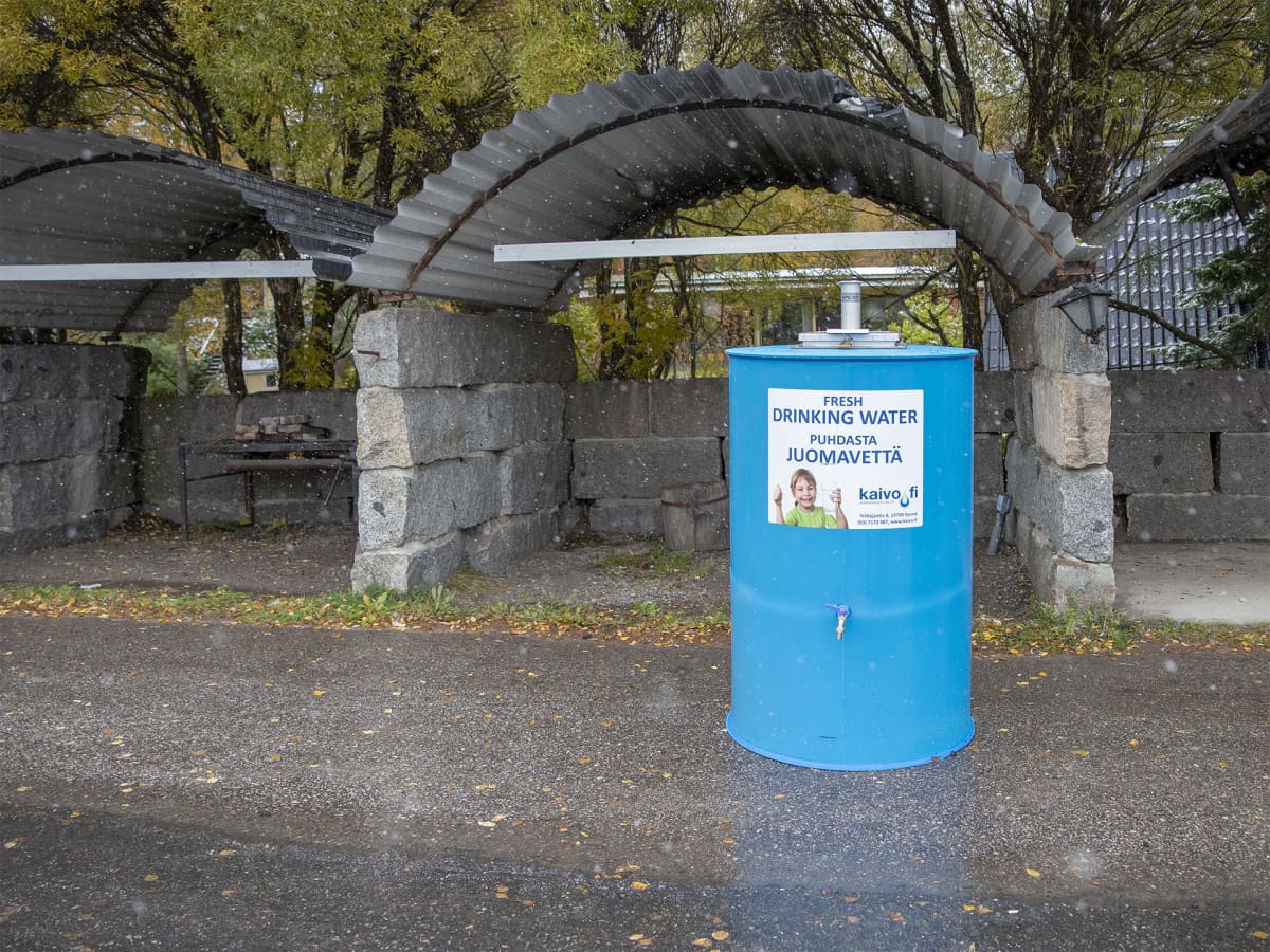 Iso sininen puhdasta juomavettä - tarralla varustettu astia Petäjävedellä kadulla. 