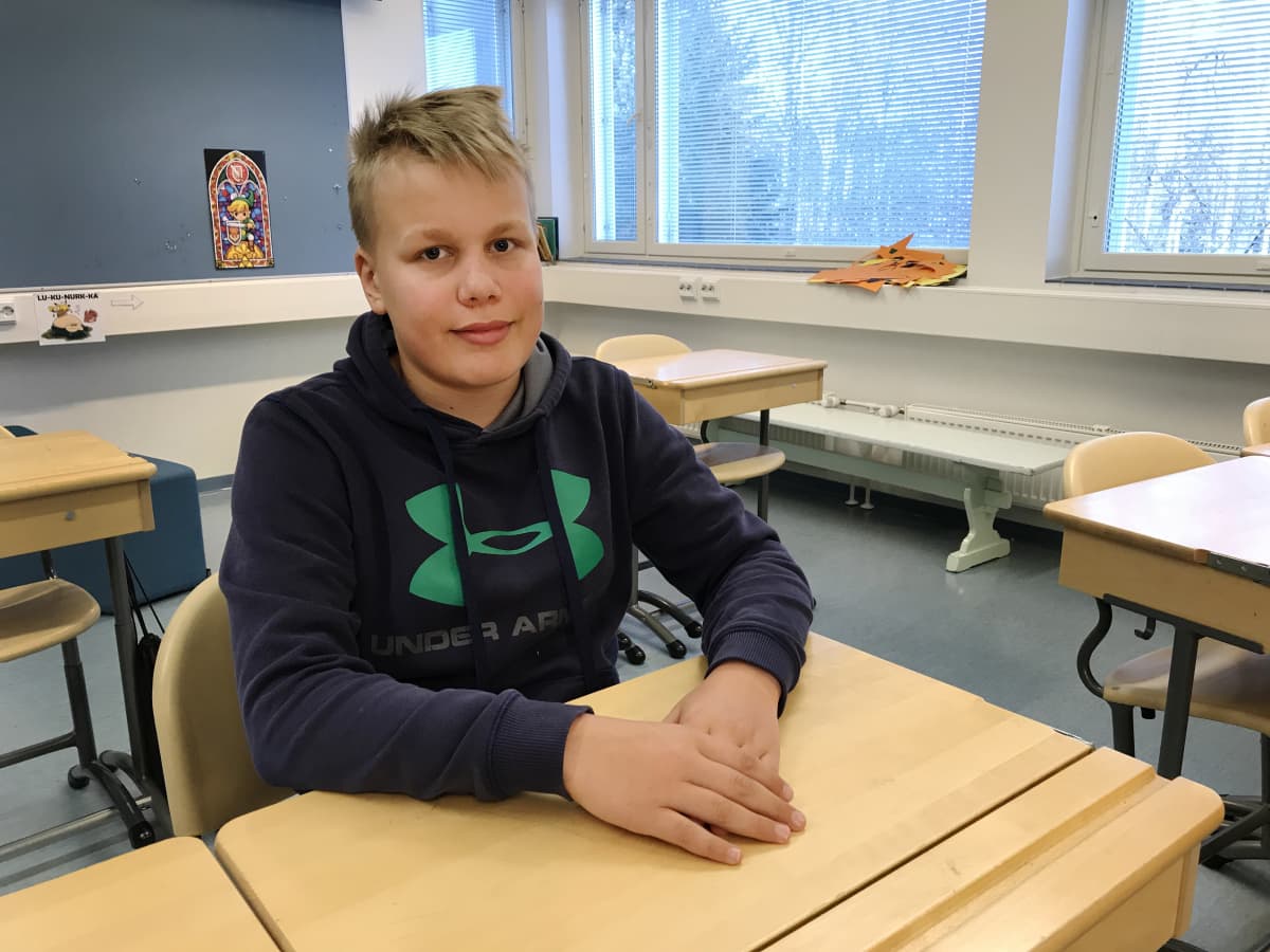 Ruutanan koulun oppilas Eemeli Salo istuu pulpetissa.
