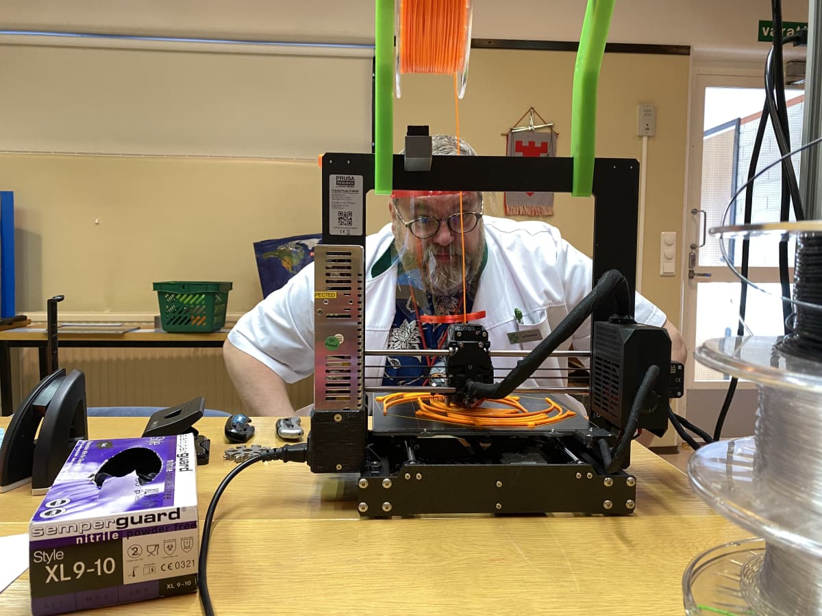 Mies tulostaa 3D-tulostimella