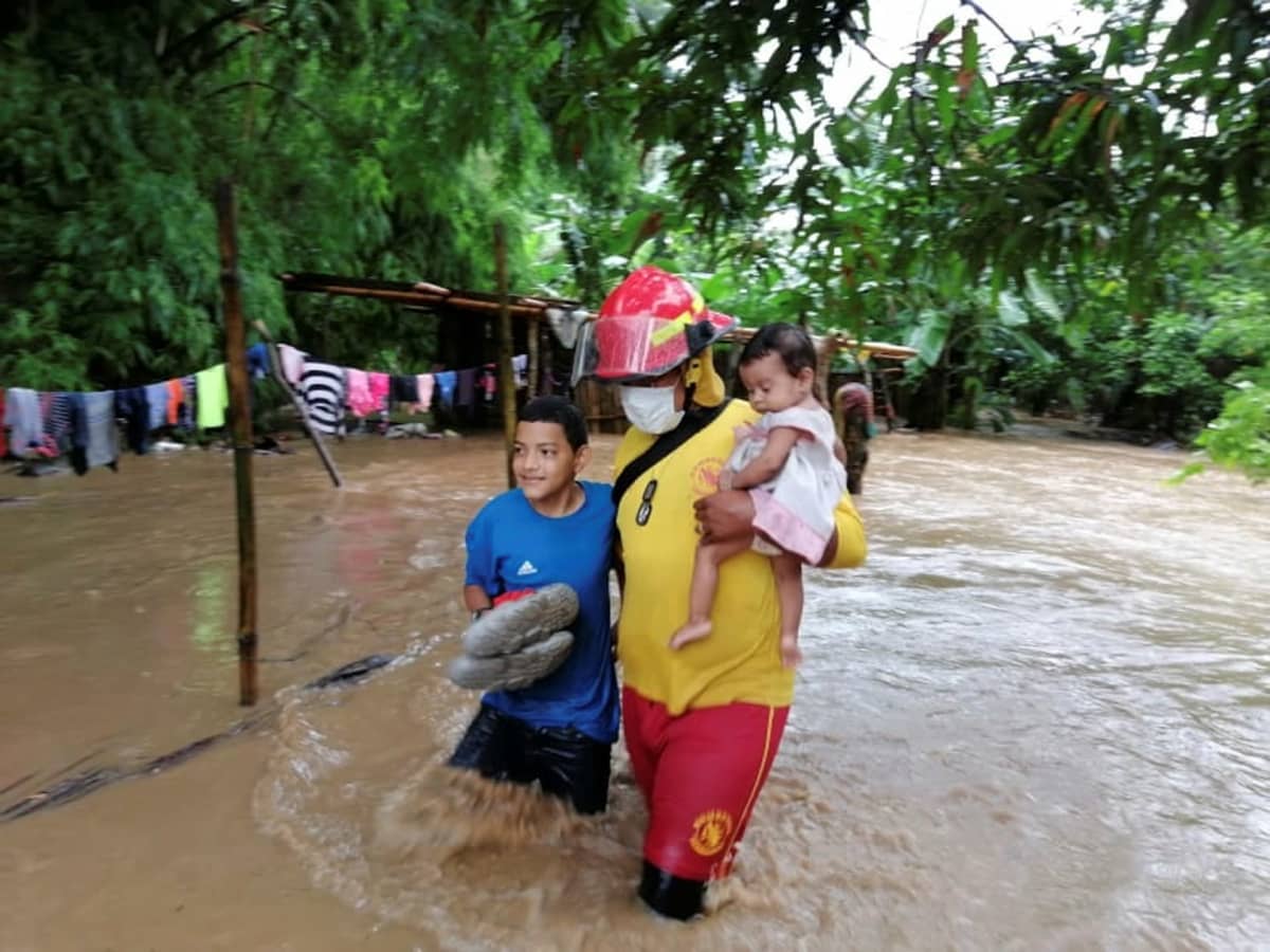 Pelastustyöntekijät auttavat ihmisiä hurrikaani Etan aiheuttaman tulvan keskellä.