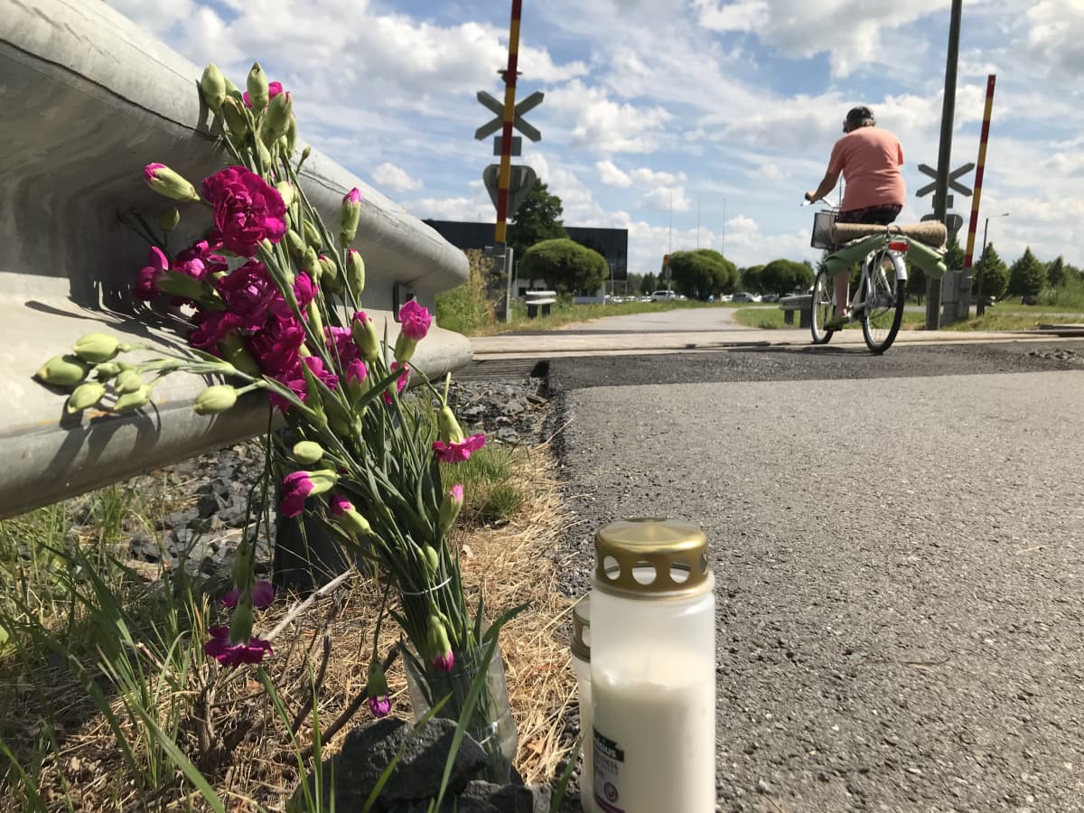 Kynttilä ja kukkia Porin Karjarannan tasoristeyksen vieressä