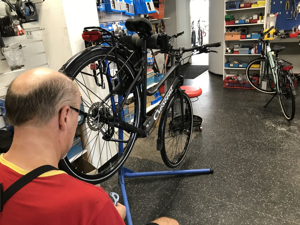 Polkupyöräkorjaaja työnsä ääressä Järvisen pyörä-liikkeessä, Lahdessa.