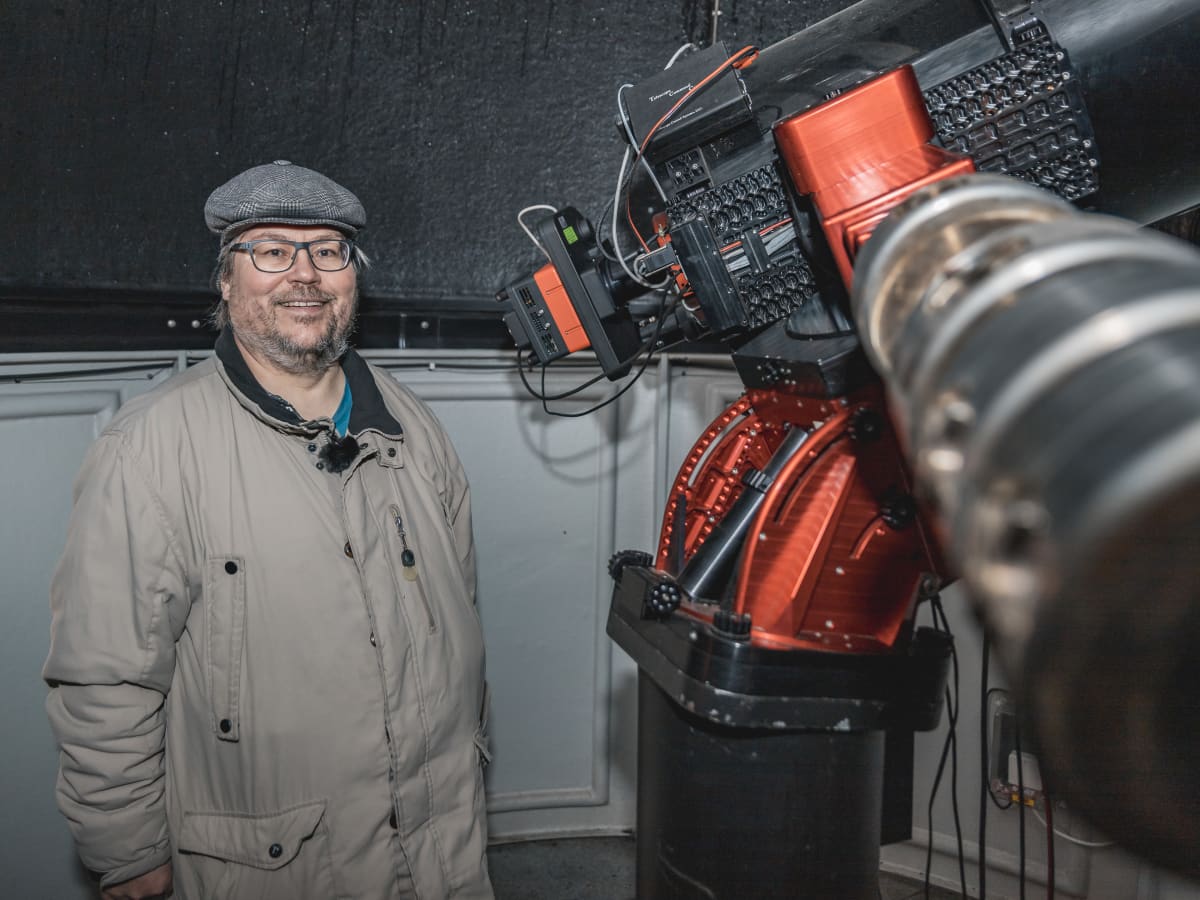 Tähtitieteen harrastaja Arto Oksanen seisoo peiliteleskoopin vierellä