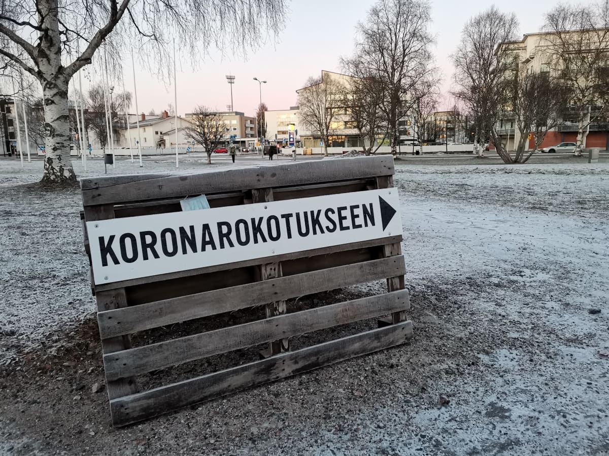 Kuormalavaan kiinnitetty Koronarokotukseen ohjaava kyltti Rovaniemen pääkirjaston edessä