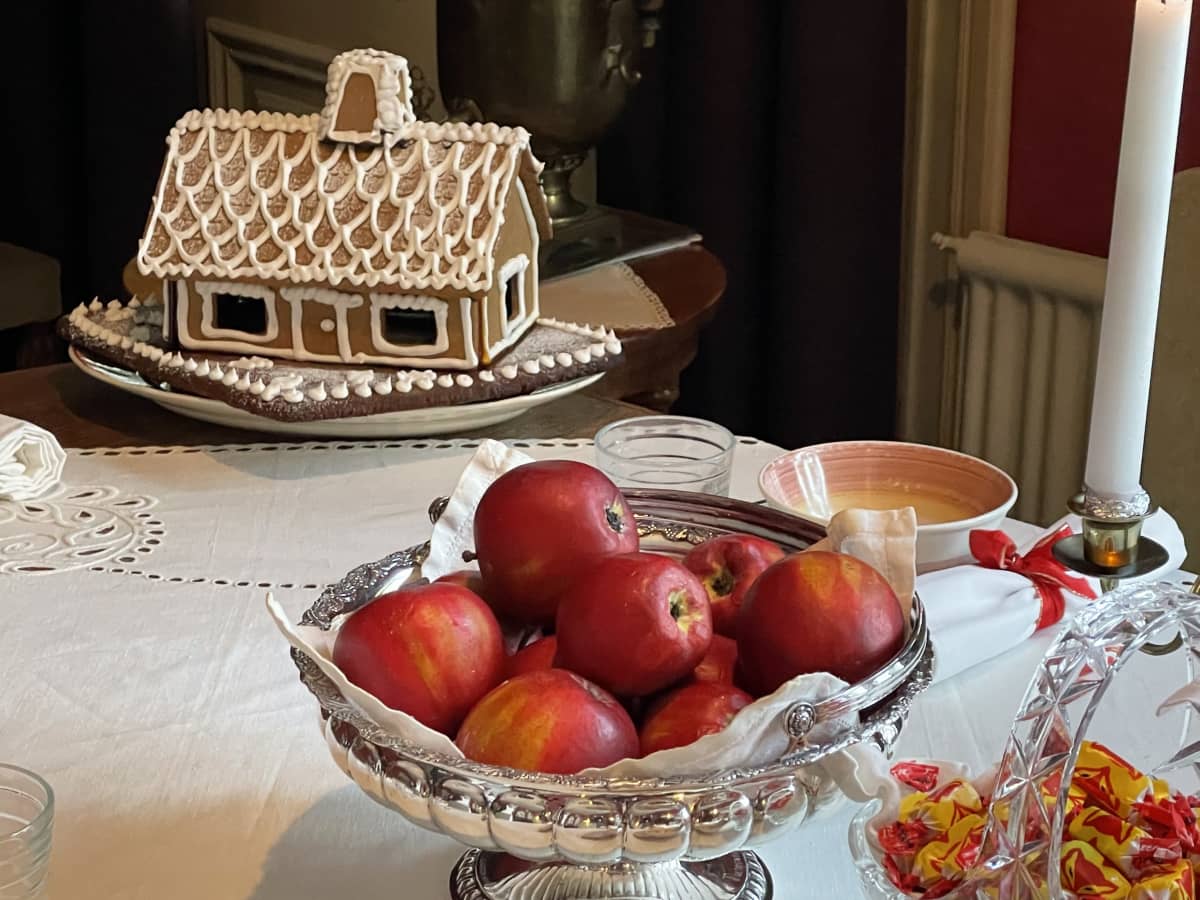 Piparkakkutalo ja omenoita Kotkaniemi-museon kahvipöydässä.