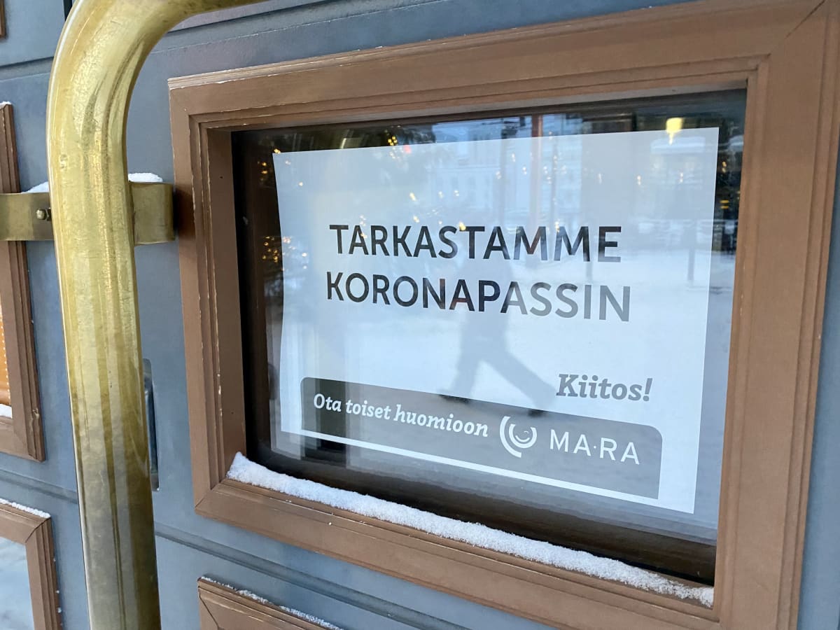 Kyltti ravintolan ovessa, joka kertoo, että koronapassi tarkastetaan. 