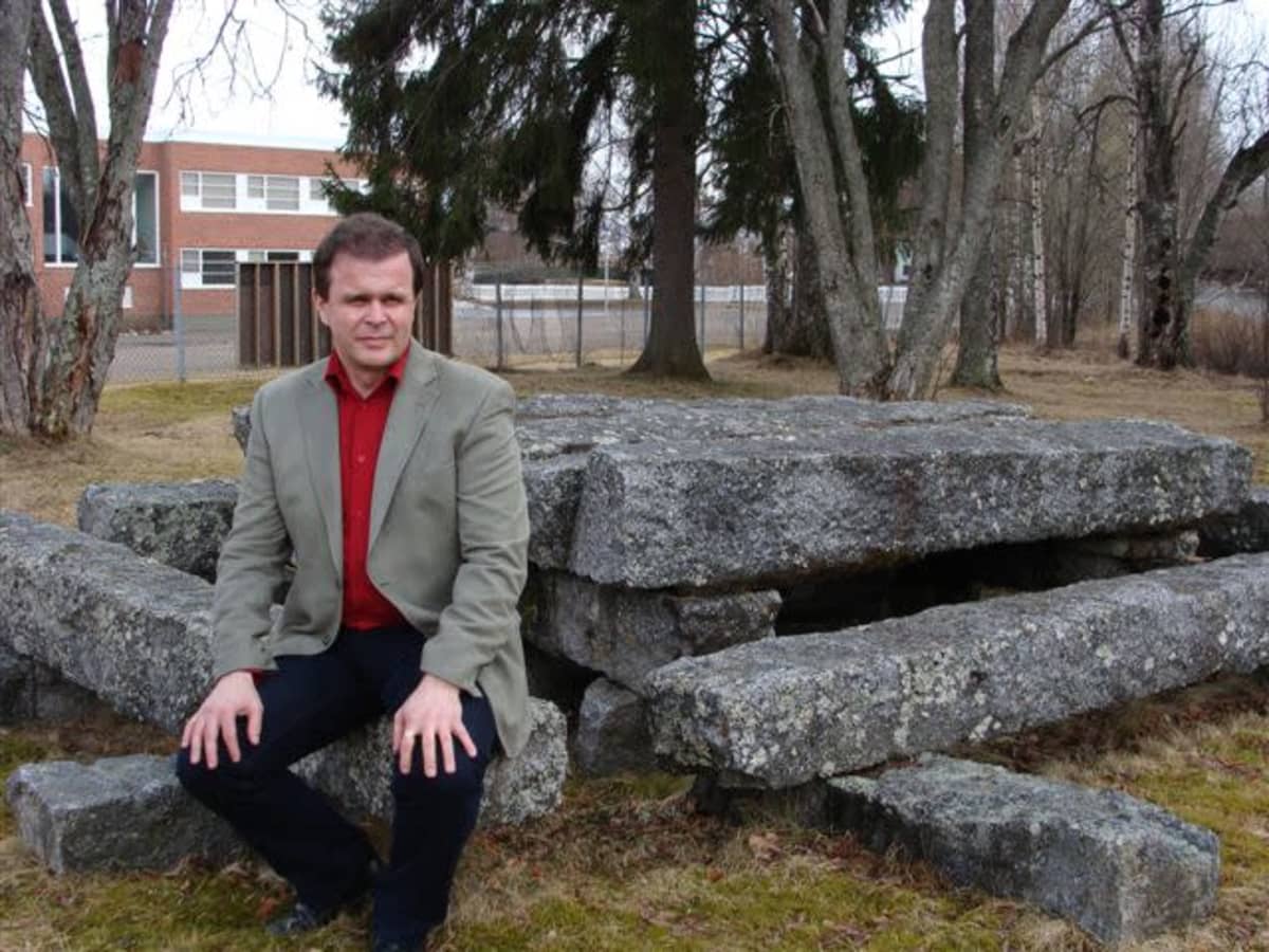 Kivijärven kunnanjohtaja Pekka Helppikangas istuu ulkona kivipenkillä.