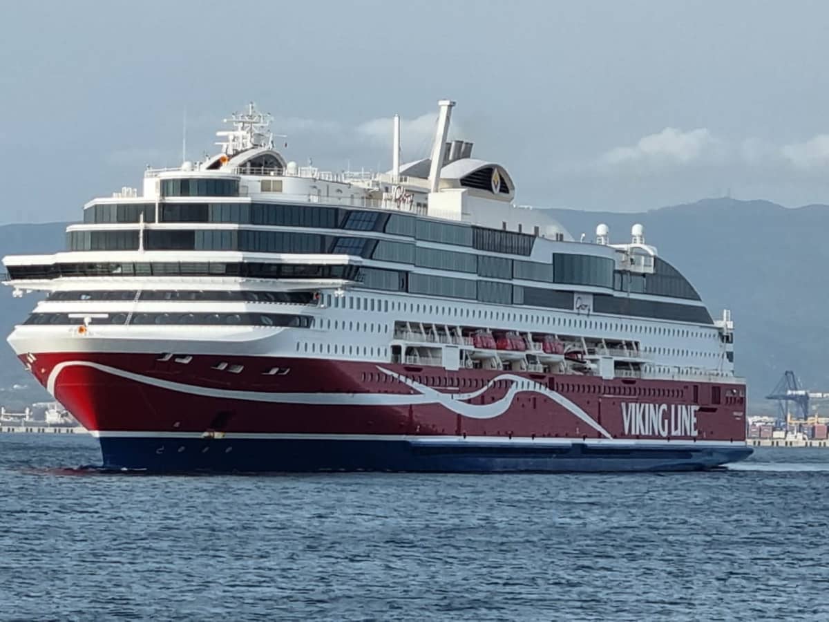 Ett röd-vitt kryssningsfartyg ute på havet nära en hamn.