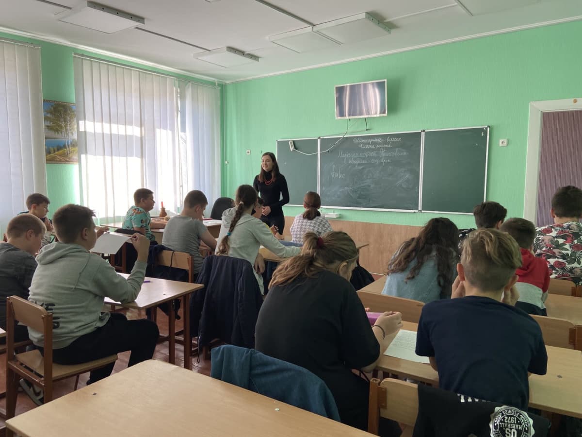 Olga Marchenko opettaa koululuokan edessä.