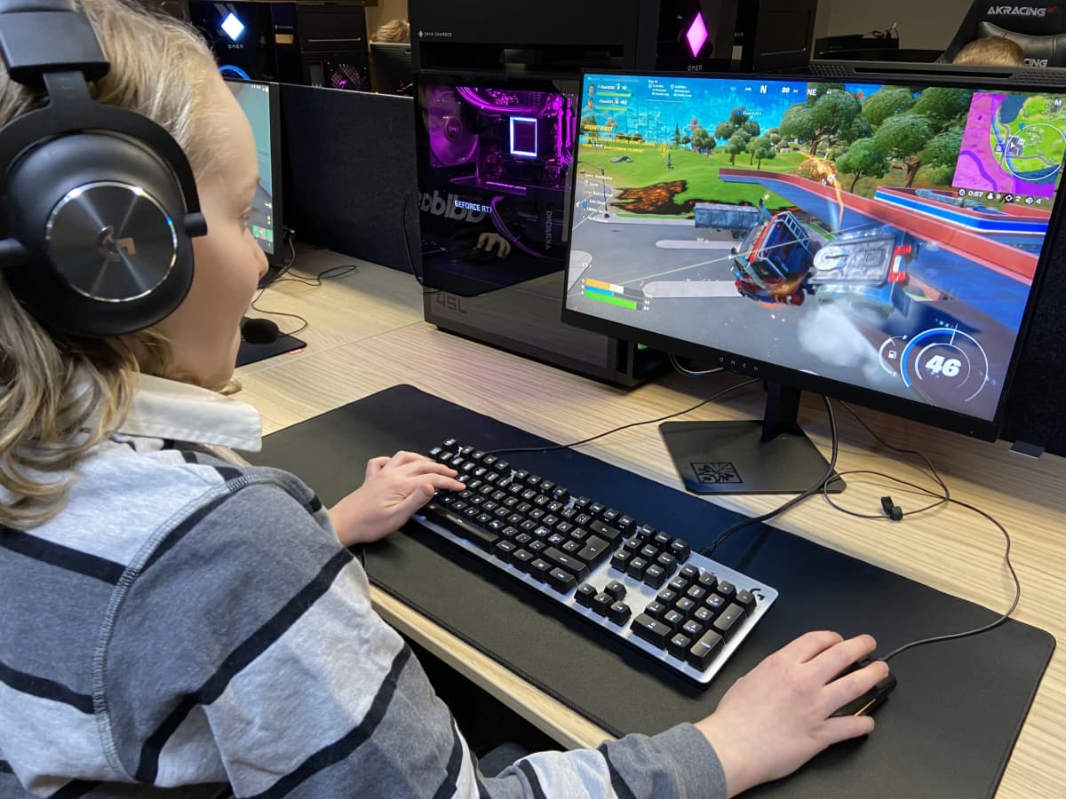Yksitoistavuotias Jaan Piitulainen pelaa pelikerhosas videopeliä. Korvilla on korvasuojaimet ja tietokoneen ruudulla on värikäs ja vauhdisa videopelil