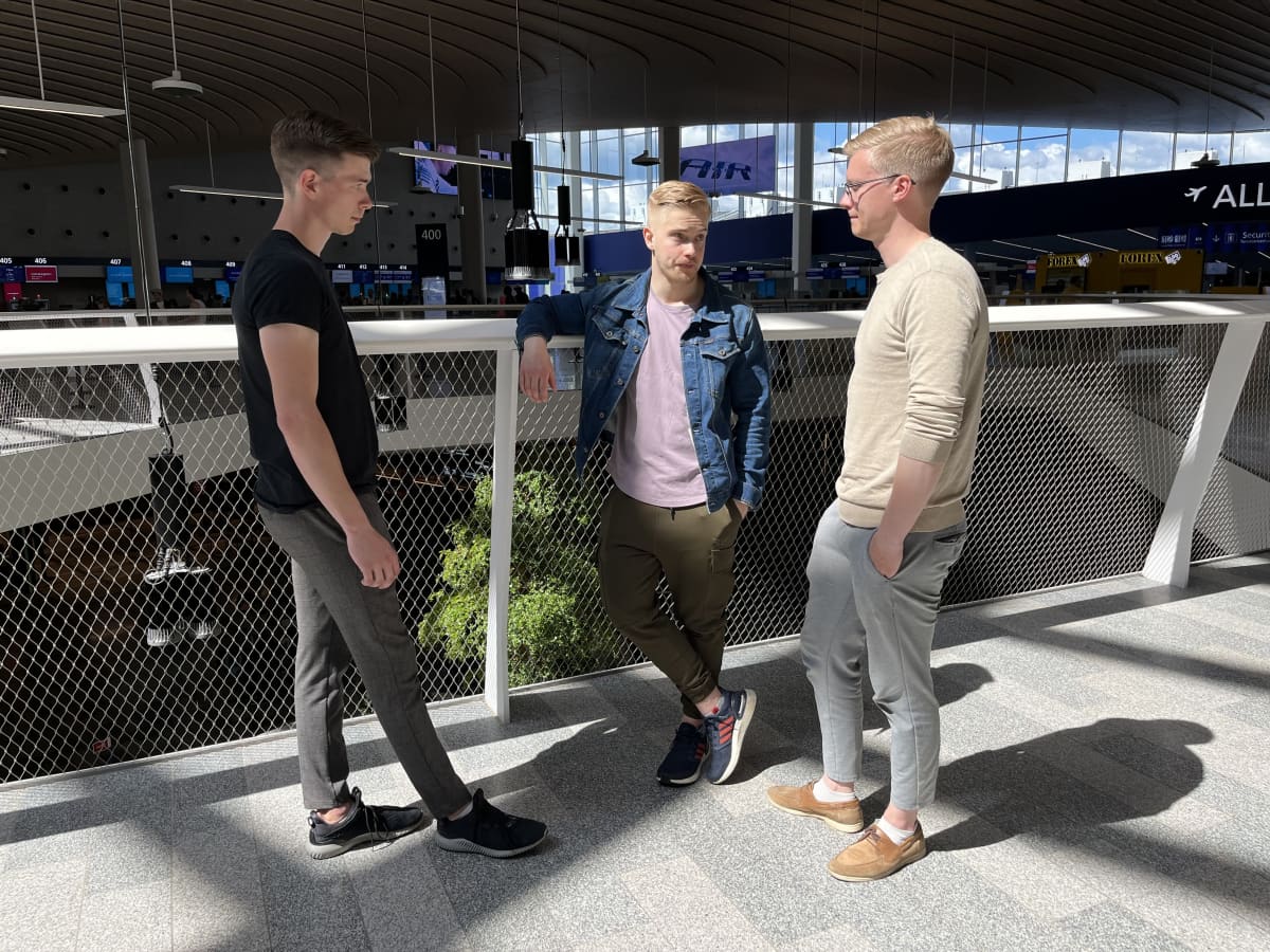Kolme nuorta miestä Helsinki-Vantaan uudessa terminaalissa.