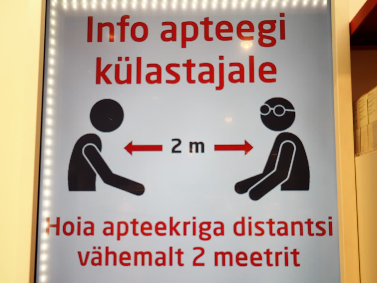 Tallinnalaisen apteekin kyltti muistuttaa, että työntekijään on pidettävä vähintään kahden metrin etäisyys.