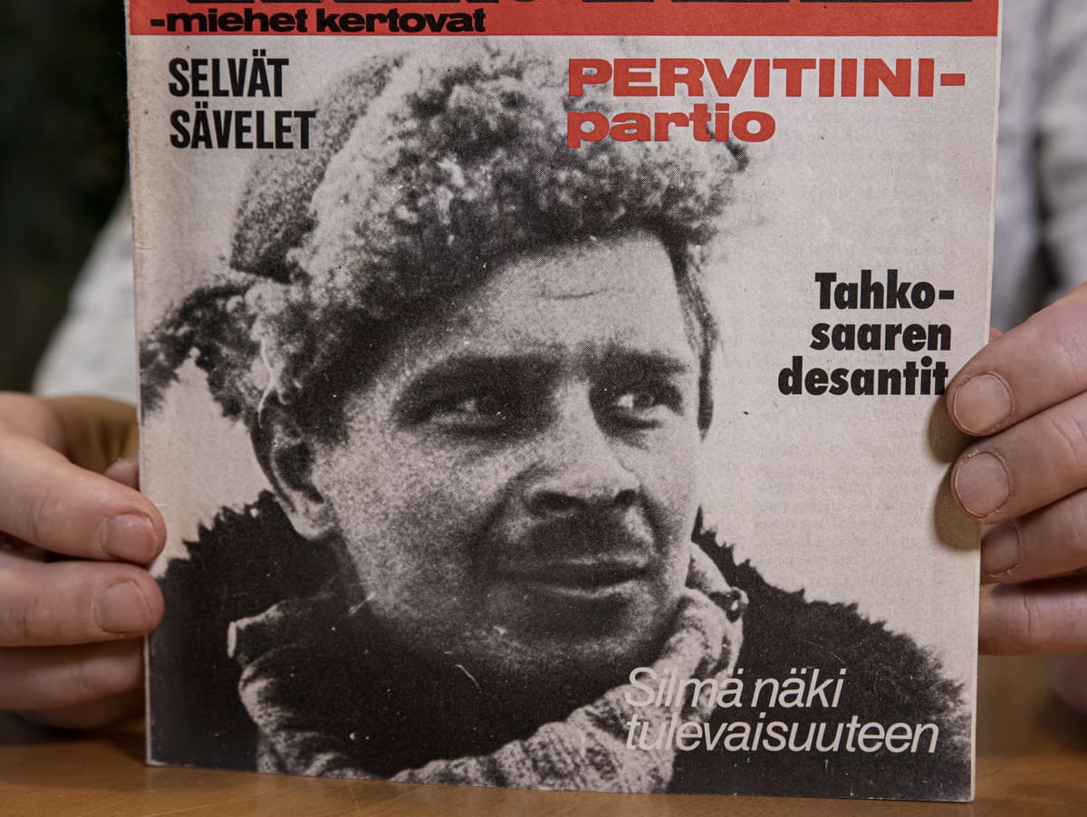 Mika Koivunen pitelee sormissaan Kansa taisteli -lehteä vuodelta 1978, jonka kannessa on hänen isänsä Aimo Koivusen kuva.