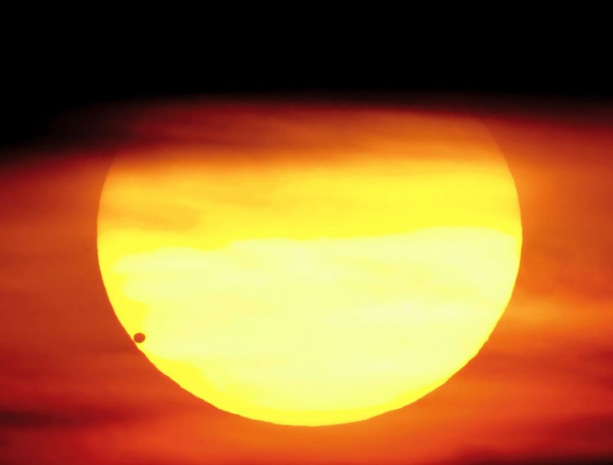 Venus tummana pallona auringon alareunassa.