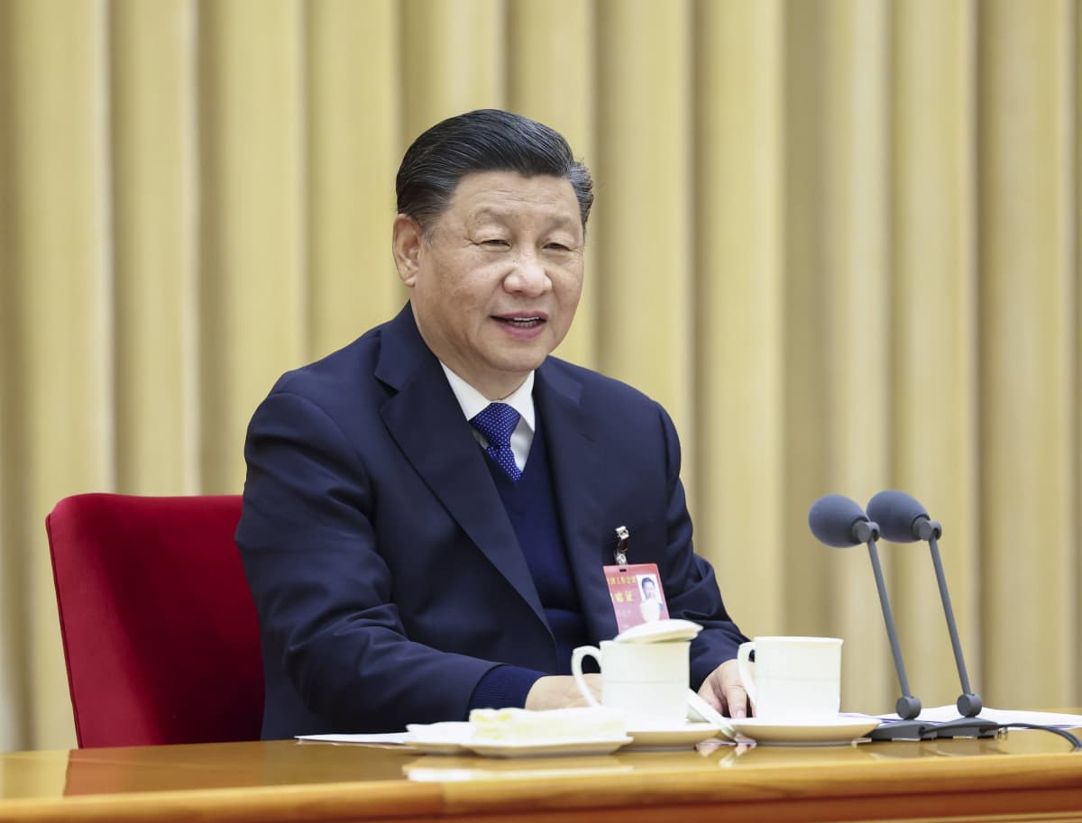 Xi Jinping istuu pöydän äärellä.