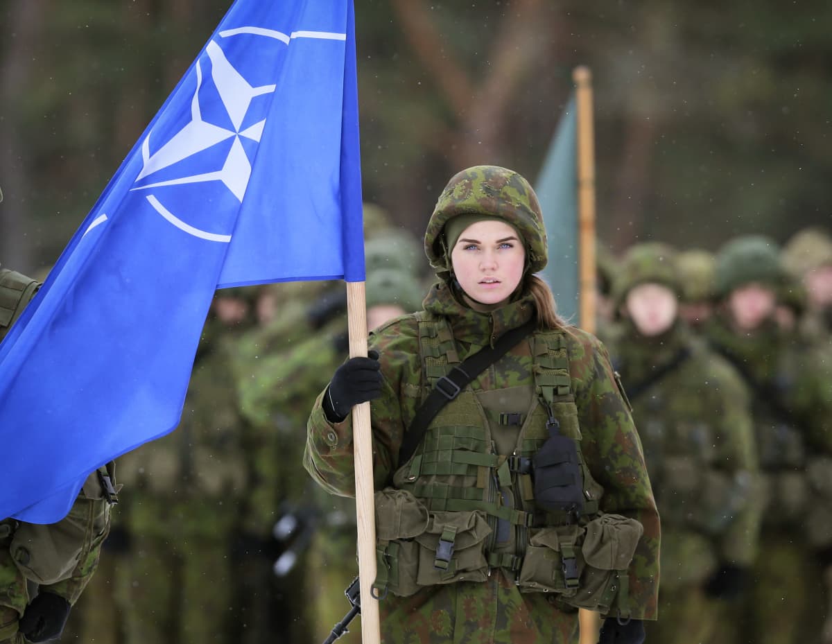 Sotilas kantaa Naton lippua.