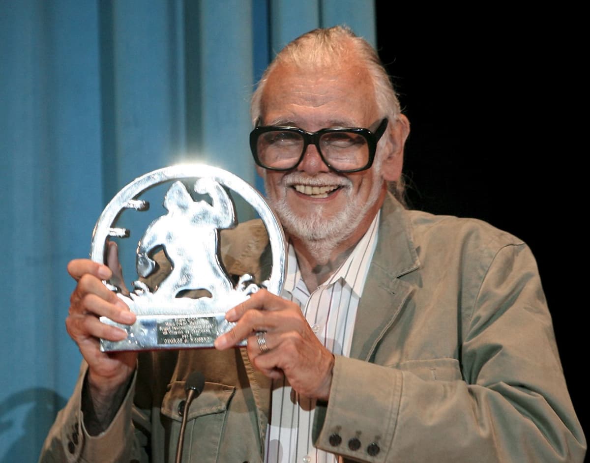 Leveästi hymyilevä Romero pitää kädessään hohtavaa palkintopystiä, johon on kuvattu King Kong.