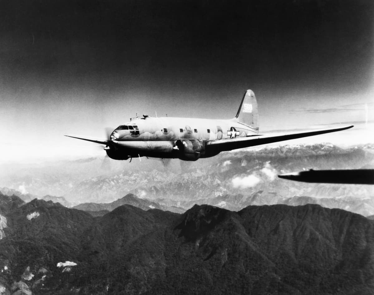 Toisen maailmansodan rahtilentokone Curtiss C-46 Commando lentää Himalajan vuoriston yläpuolella.