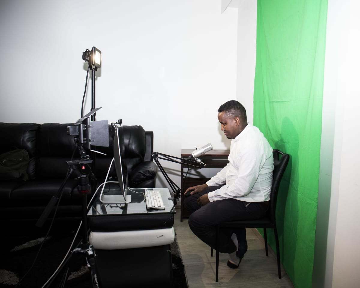 Hassan Halanen juontamassa podcast lähetystä omassa olohuoneessaan.