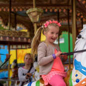 Lapsi matkustaa karusellissa hevosella
