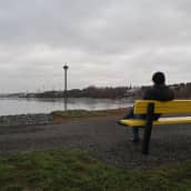 Mies istuu puiston penkillä Näsijärven rannalla