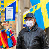 Hengityssuojaan pukeutunut mies kävelee kadulla Tukholmassa.