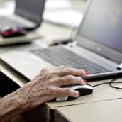 Eläkeläisnainen käyttää tietokonetta.