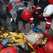 Turkin hätätilaviranomaisten julkistama kuva pelastajista, jotka kantavat nelivuotiasta Ayda Gezginiä turvaan maanjäristyksessä romahtaneen talon raunioista Bayraklin alueella Izmirissä. 