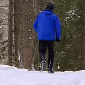 mies sauvakävelee lumisella tiellä