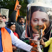 Mielenosoittajat sytyttävät tuleen Greta Thunbergin kuvaa.