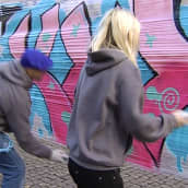 Graffittitaiteilija Hende ja Lähiöprinsessa Tanja Drca maalaavat graffittia kankaalle Kiasman edessä.