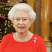 Kuningatar Elisabet puhuu, taustalla joulukuusi.