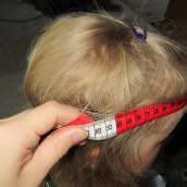 lapsen päänympäryksen mittausta mittanauhalla