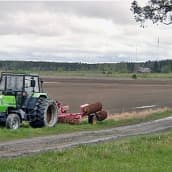 Traktori pellon reunalla.