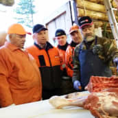 Lihamestari Erkki Halonen näyttää lihanleikkaamisen mallia Isokylän miehille