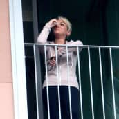 Nuori vaalea hiuksinen nainen katsoo ikkunasta ulos pyyhkien nenäliinalla silmäänsä. 