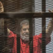 Egyptin syrjäytetty presidentti Muhammad Mursi elehti kameroille vakoiluoikeudenkäynnissä Kairossa lauantaina.