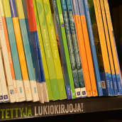 Käytettyjä lukiokirjoja kirjakaupan hyllyssä.