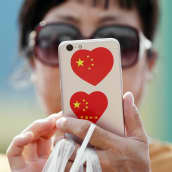 Kiinalainen nainen tutkii kännykkäänsä.