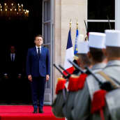Kuvassa vasemmalla Emmanuel Macron, etualalla sotilaita selin kameraan. 