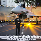 Tom Cruise poseeraa hävittäjäkoneen edessä.
