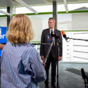 Harmaantunut liikemies seisoo sinivalkoisen Uniper-kyltin edessä, toimittajien mikit osoittavat eri suunnista hänen eteensä.