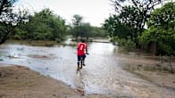 Malawialainen mies pyöräilee tulvavedessä Chikwawassa
